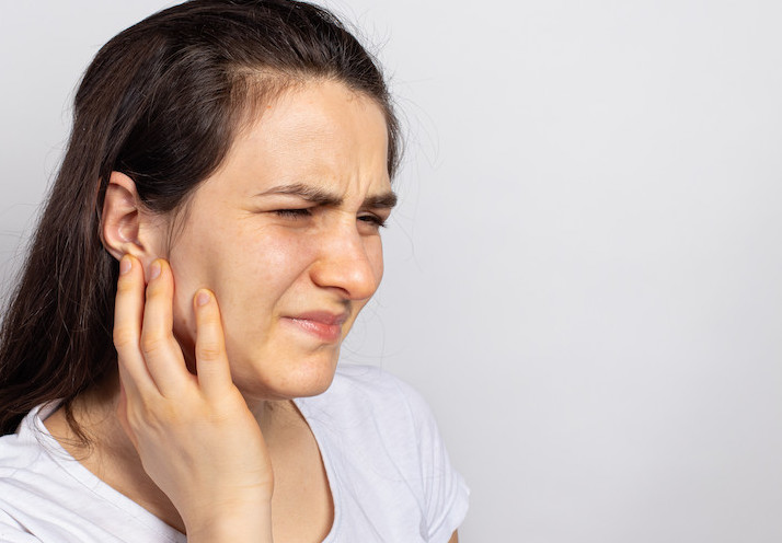 The woman has a sore ear - infection, inflammation from infection and otitis. Perforation ruptured the eardrum. Arthritis of the temporal lower jaw joint, osteoarthritis and pain in the jaw, mastoiditis
